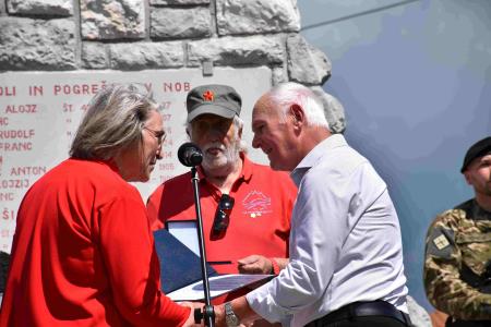 Osrednja govornica predaja plaketo v roke Jožetu Sloslu
